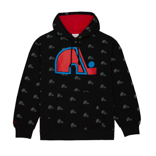 A black Quebec Nordiques hoody. Miniature Nordiques logos are all over the hoody, with a large red and blue logo placed on the center of the hoody. A red Mitchell and Ness letter logo is on the right wrist.