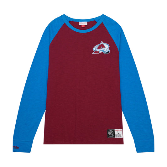 Burgundy long sleeve shirt with blue sleeves that run from shoulder to wrist, Mitchell and Ness embroidered on right wrist, a full colored Avalanche logo on the left breast, and a size tag near the left hip.